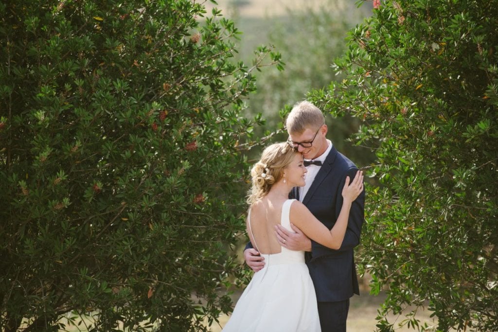 bride and groom hugging in an orchard